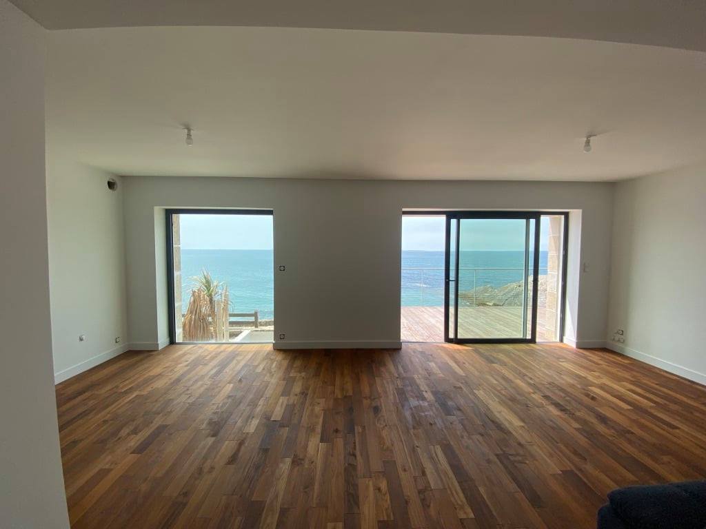Séjour rénové avec parquet et baies vitrées, réalisé par Quévarec